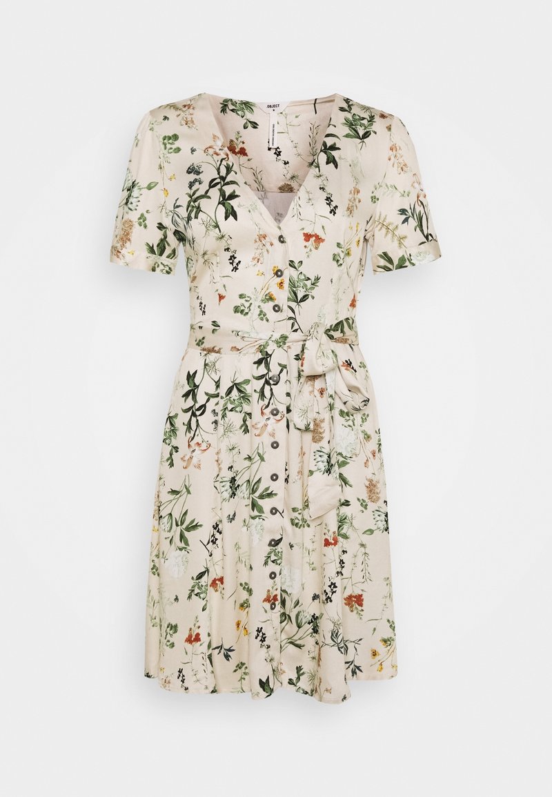 Robe crème à manches courtes avec col en V, boutonnée sur le devant, ceinture à la taille, et imprimé floral vert, orange et jaune sur toute la surface.