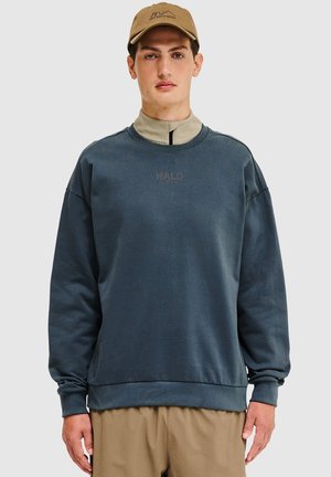 Mörkblå sweatshirt med rund halsringning, ribbade ärmslut och midja. Har en liten "HALO"-logotyp i kontrasterande färg, tillverkad av ett mjukt material.