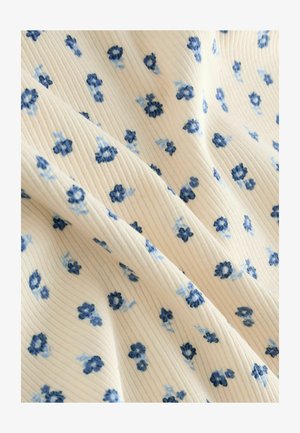 Geribbelde stof met een crèmekleurige achtergrond en verspreide blauwe bloemmotieven. De textuur lijkt zacht met een lichte glans.