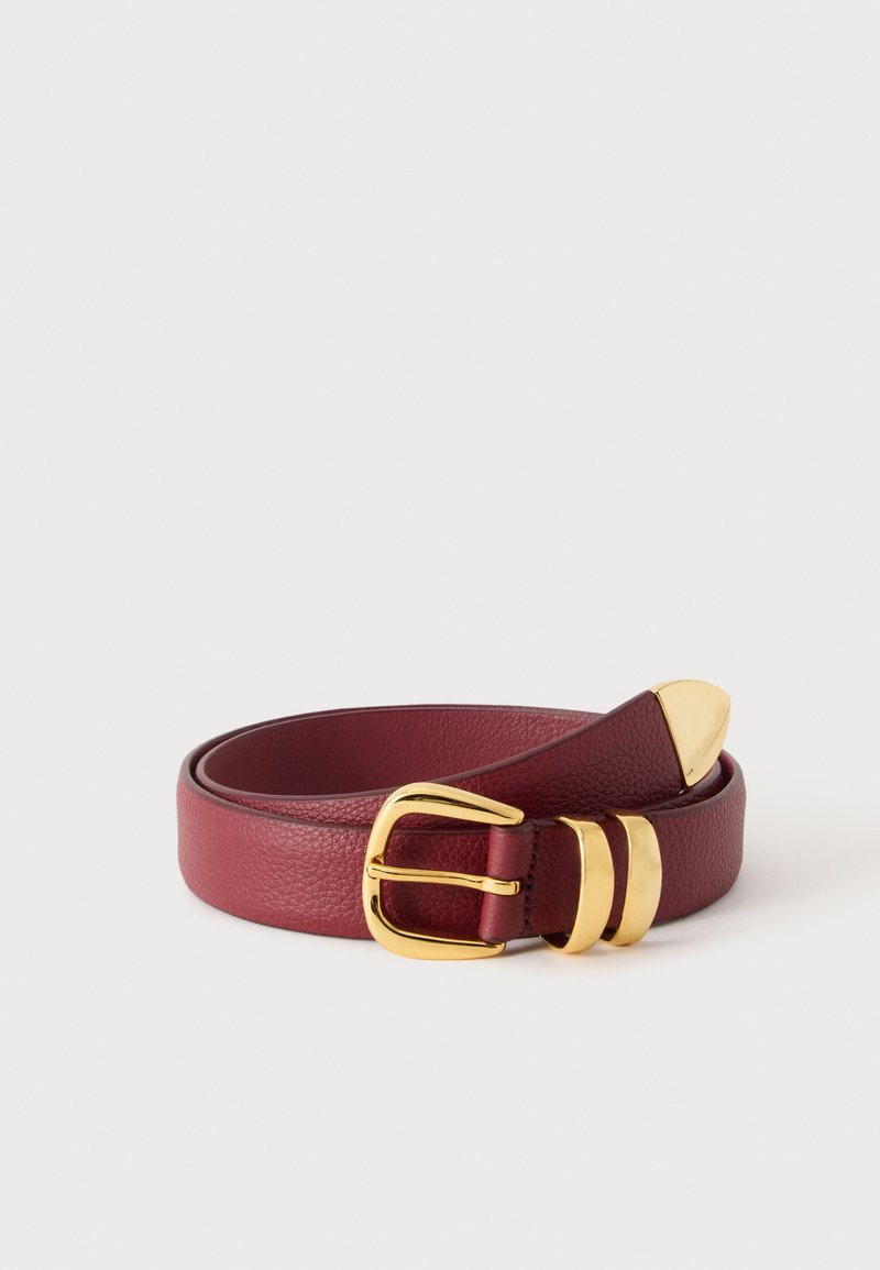 Ceinture en cuir bordeaux enroulée avec boucle rectangulaire dorée, deux passants dorés et extrémité dorée sur fond clair uni.