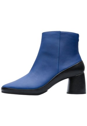 Bottine bleue à bout carré arrondi et talon bloc noir épais et évasé, présentée de profil gauche sur fond blanc.