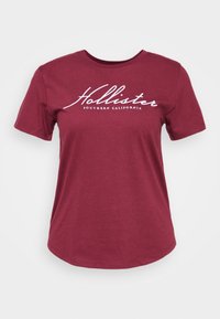 Camiseta de algodón burdeos, de cuello redondo y mangas cortas, con el logotipo blanco de "Hollister" y el texto "SOUTHERN CALIFORNIA" en un tipo de letra casual.
