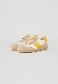 Sneaker in suede beige con dettagli bianchi e gialli, con design low-top, punta arrotondata e suola testurizzata.