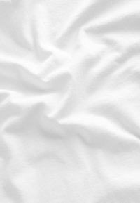 Tessuto di cotone bianco con una texture liscia, che mostra pieghe e piegature ovunque, creando un aspetto organico e fluido.