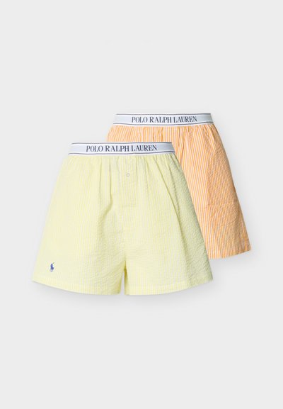 Δύο ζευγάρια ριγωτά αντρικά μπόξερ Polo Ralph Lauren σε παστέλ κίτρινο και πορτοκαλί με λευκές ζώνες μέσης με το λογότυπο της μάρκας.
