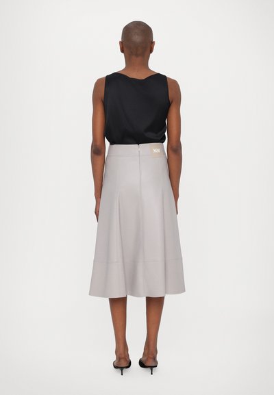 Svart ermeløs topp kombinert med en lys grå midi-skjørt, med glidelås foran og et lite merkelapp bak. Glatt tekstur.