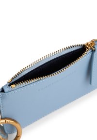 Portafoglio in pelle blu con cerniera e dettagli dorati. Presenta una texture liscia e un vano interno con fodera scura.