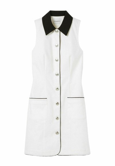 Vestido blanco sin mangas con cuello y ribete negro, con botones en la parte delantera y dos bolsillos laterales. Textura suave y diseño clásico.
