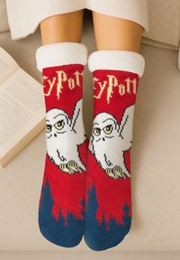 Calzini rossi con un design di gufo bianco con dettagli neri, polsini color crema e una sezione della punta blu. Il testo "Harry Potter" è integrato.