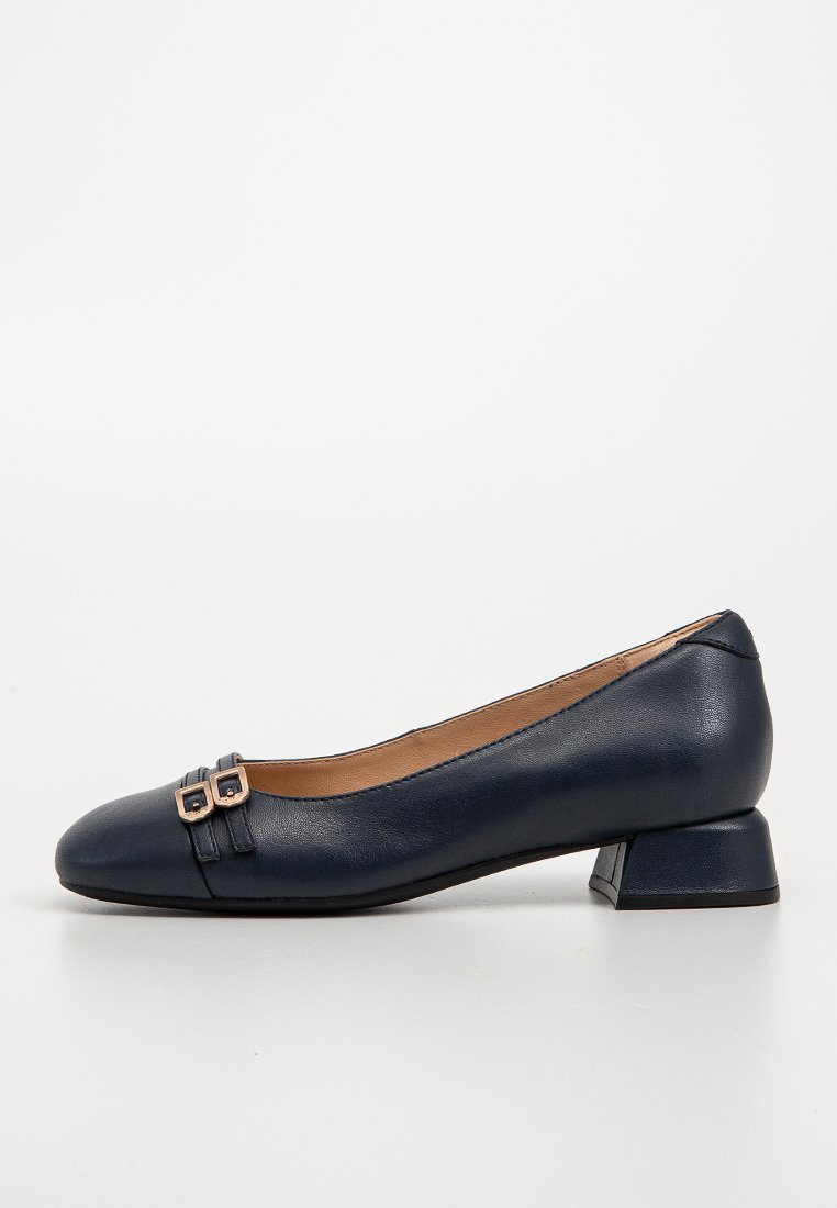 Marineblaue Leder-Ballerinas mit niedrigem Absatz, abgerundeter Spitze und zwei dekorativen Schnallen auf der Vorderseite. Glatte Textur und schlichtes Design.