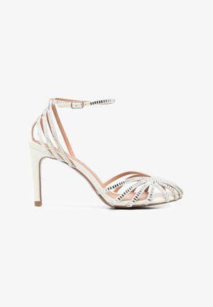 Sandalo bianco con tacco alto, sottili cinturini argentati lucidi, fibbia alla caviglia e design a punta aperta.