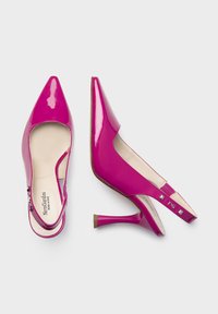 Jasnoróżowe lakierowane buty slingback z ostrymi noskami, 7 cm obcasem i dekoracyjnymi akcentami na pasku. Miękka beżowa wyściółka.