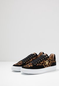 Baskets à imprimé léopard avec une base en daim noir, des accents en matière dorée et une semelle en caoutchouc blanc avec une traction texturée.