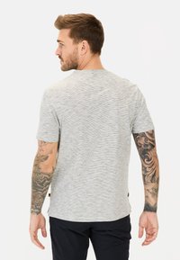 T-shirt gris à manches courtes avec un motif rayé horizontal subtil, fabriqué en tissu doux, avec un col rond et une coupe décontractée.