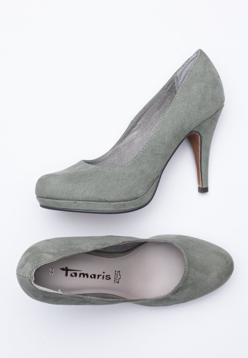 Une paire de chaussures à talons hauts en suede gris pour femmes, l'une vue de côté et l'autre vue de dessus, montrant la semelle intérieure de la marque Tamaris.