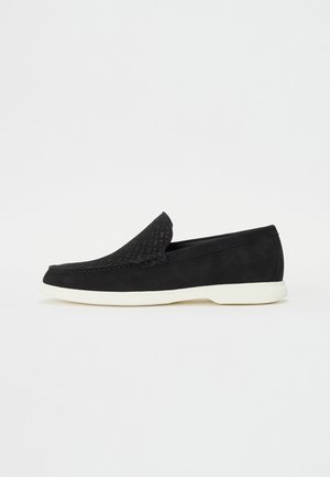Juodos slip-on bateliai su tekstūruota viršutine danga ir glotniu juodu kulnu. Yra baltas guminis padas, elegantiškas dizainas ir minimalus dekoras.