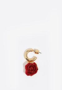 Złote kolczyki w kształcie dużych kół z zawieszką w kształcie czerwonej róży, charakteryzujące się połyskującą teksturą oraz metalowym zapięciem zapewniającym bezpieczne mocowanie.