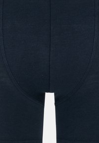Mörk marinblå herrboxer med elastiskt tyg. Har en slät textur och elastisk midja med en åtsittande design.