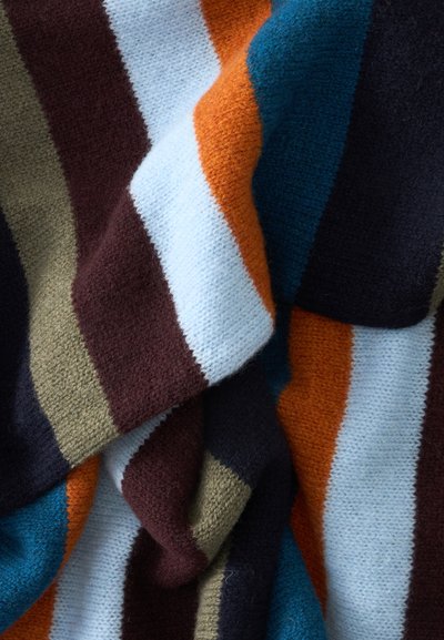 Tissu tricoté doux avec larges rayures verticales en marron, blanc, orange, sarcelle, olive et noir, présenté en gros plan avec des plis.