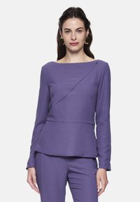 Purple long-sleeve top in textured fabric with a boat neckline, featuring a diagonal seam detail and peplum silhouette.