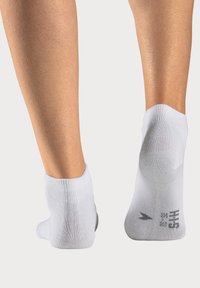 Weisse Knöchel-Socken aus einem weichen, dehnbaren Material. Mit einem gerippten Bündchen und glatter Textur, Größe und Markenlogo auf der Unterseite aufgedruckt.