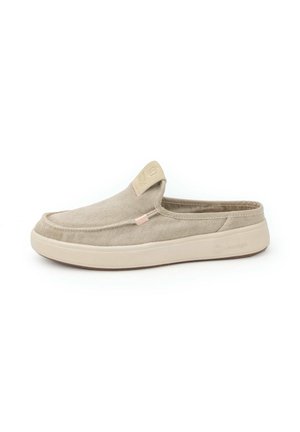 Beige slip-on mule shoe with canvas upper and thick rubber sole, featuring a padded collar and subtle branding on heel and tongue tab.