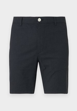 Czarne szorty o długości do kolan z zapięciem na guzik i zamek, szlufkami na pasek oraz prostym krojem na jednolitym jasnym tle.