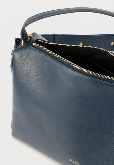 Mørkeblå lædertaske med en struktureret form, toplynlås og guldfarvet hardware. Har en glat tekstur og en indvendig lomme.