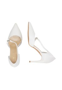 Fehér, hegyes orrú, nyitott oldalú magassarkú cipők, bokapánttal. Simaságú bőrfelület és vékony stiletto sarok. Minimalista dizájn.