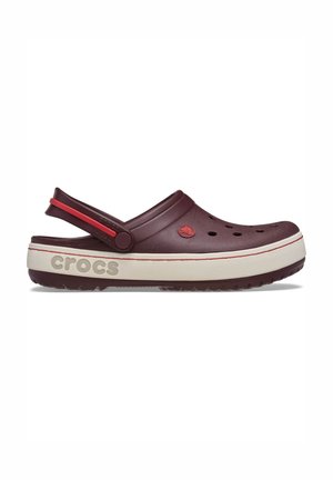 Sabot Crocs bordeaux avec des trous de ventilation, une semelle intermédiaire blanche avec le logo "crocs", et une bride de talon ajustable accentuée de rouge.