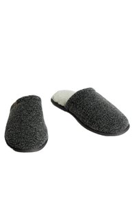 Chaussons en feutre gris texturé avec une doublure en polaire blanche douce et des semelles en caoutchouc noir solide. Design à l'arrière ouvert pour un enfilage facile.