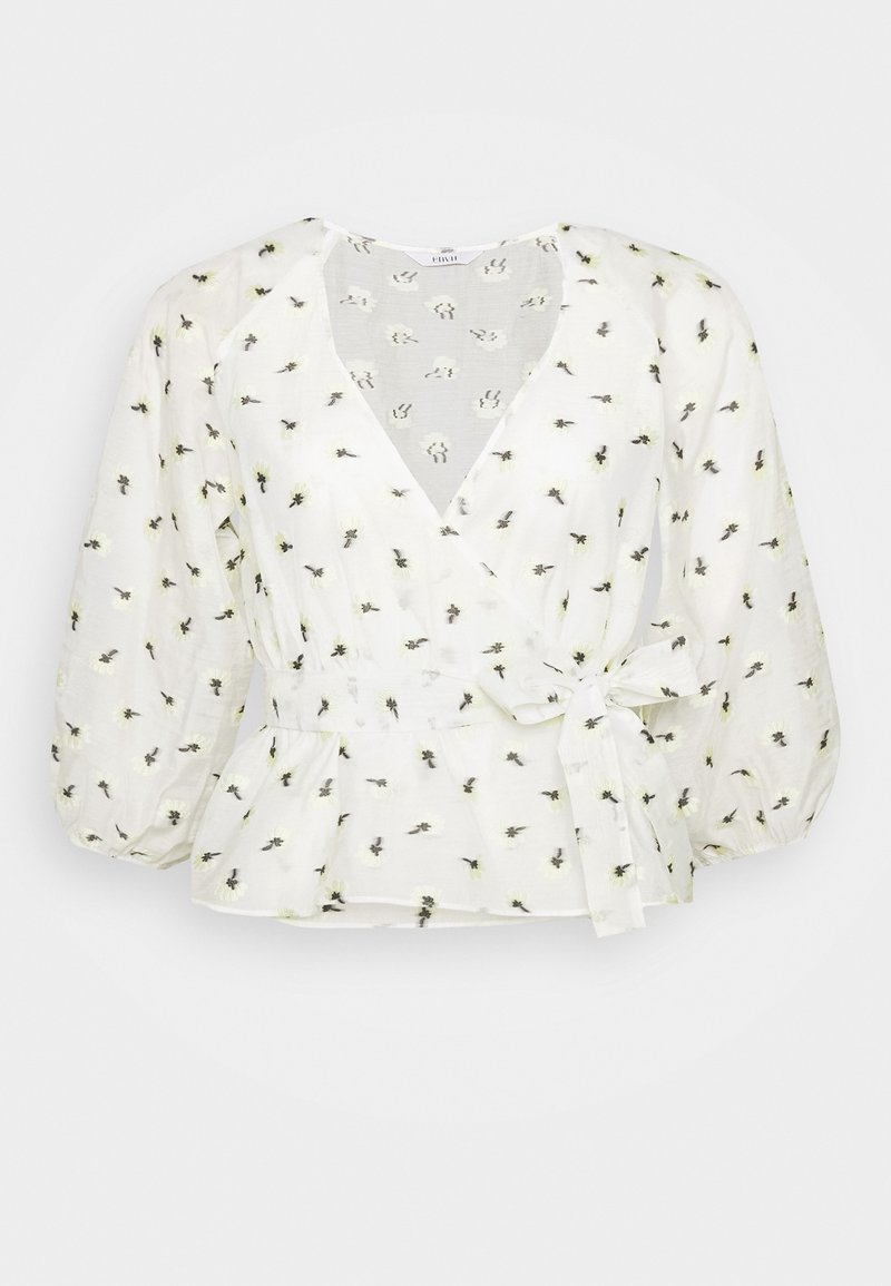 Blouse blanche avec peplum, col en V, manches bouffantes et taille à nouer. Présente une broderie florale en noir et jaune sur un tissu léger.