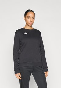 Μαύρο φούτερ με μακριά μανίκια και στρογγυλή λαιμόκοψη, με ριμπ τελείωμα και λευκό λογότυπο Adidas στο αριστερό στήθος. Απαλό ύφασμα και άνετη εφαρμογή.