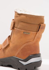 Brązowy skórzany botek za kostkę z ociepliną z owczej wełny, rzepem, logotypem Gore-Tex, solidną podeszwą oraz kontrastującymi czarnymi i srebrnymi akcentami.