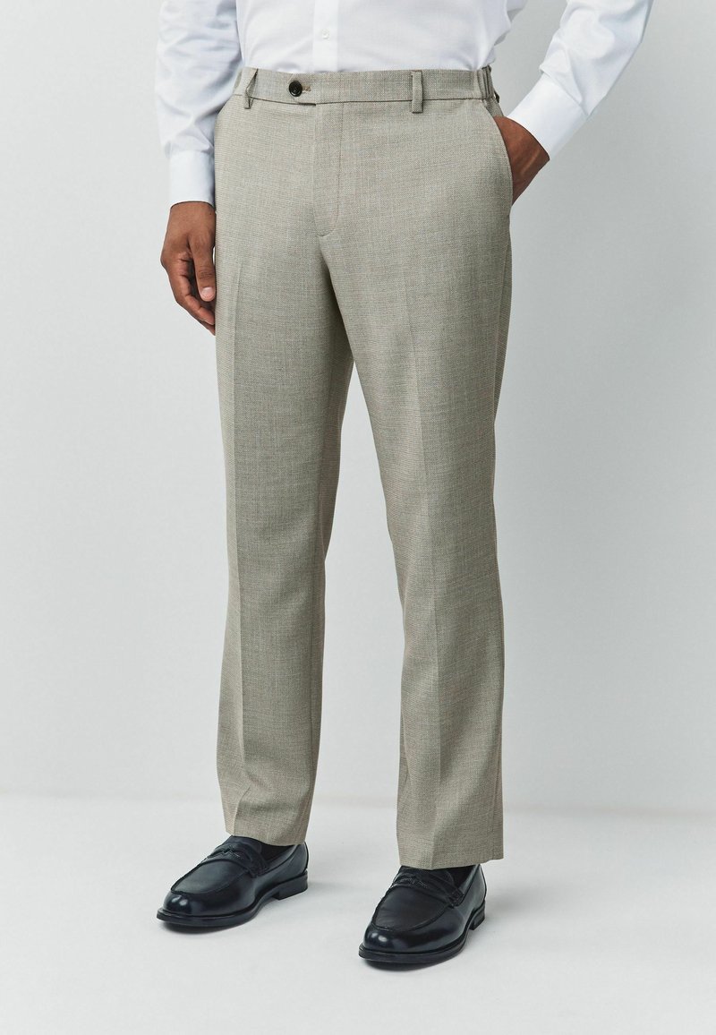 Light gray tailored trousers with a textured weave, flat front, belt loops, and a single button closure. Paired with black dress shoes.