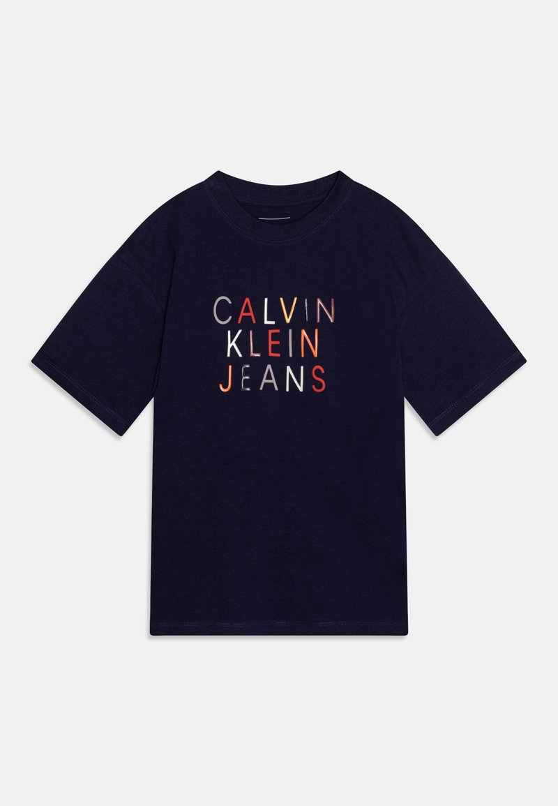 Mørkeblå bomulds T-shirt med korte ærmer. Har "CALVIN KLEIN JEANS" tekst i forskellige farver på forsiden. Rund halsudskæring.