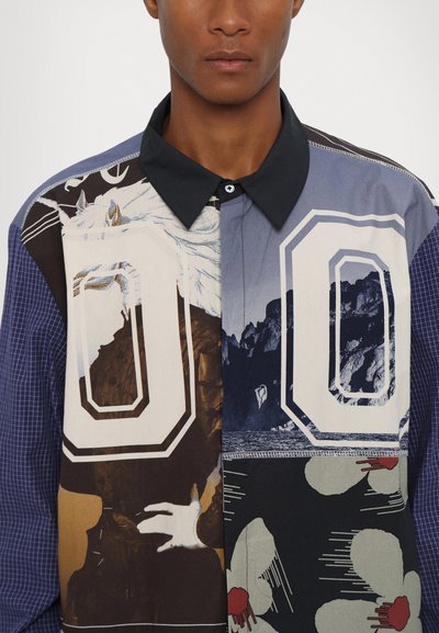 Colorful shirt featuring various patterns: black and white graphics, blue and brown sections, a plaid texture, and a contrasting collar.