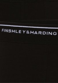 Boxers noirs avec une ceinture blanche sur laquelle est inscrit le logo "FINSHLEY&HARDING". Tissu doux avec une texture élastique pour un confort optimal.