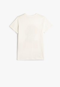 Vit bomulls t-shirt med korta ärmar och rund halsringning. Bakdelen har en bleknad grafisk design i en ljus färg.