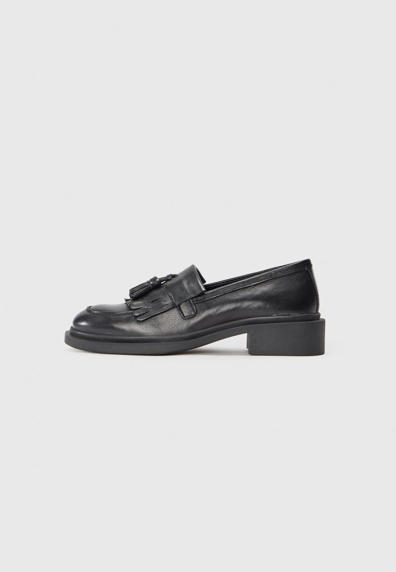 Black leather loafers with a low block heel, featuring a decorative tassel and fringe detail on the vamp, smooth texture, and rounded toe.