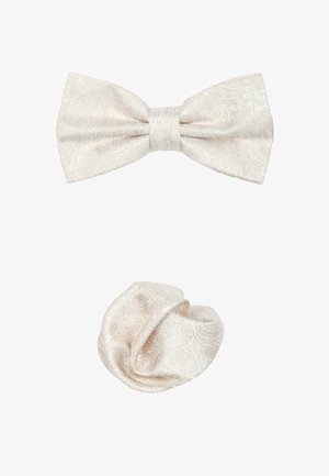 Nœud papillon de couleur crème et chouchou assorti fabriqués en tissu texturé avec un subtil motif floral. Le nœud papillon a une forme classique, tandis que le chouchou est froncé.