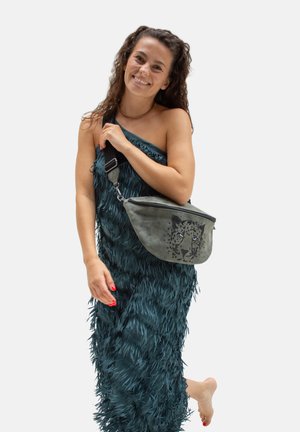 Marsupio in tessuto grigio con design di faccia di leopardo, indossato a tracolla, abbinato a un vestito teal con texture a piuma.
