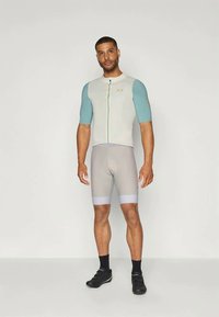 Meeste jalgrattariietus, mis sisaldab halli lühikeste varrukatega keha lähedalt istuvat särki siniste varrukatega, lukuga esiosa ja halli lühikesi pükse valgete detailidega.