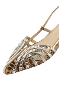 Zapato de tacón slingback en tono dorado con puntera afilada, adornado con cuentas plateadas en un patrón de arco, que presenta un acabado brillante y una tira delgada.
