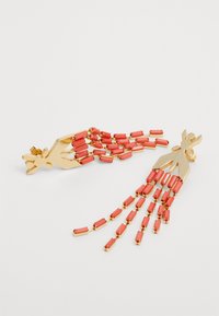 Gullfargede øreringer med et hånddesign, pyntet med korallfargede rektangulære perler som skaper en kaskadeeffekt.