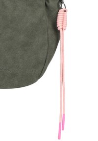 Borsetta in suede verde oliva con superficie texturizzata, dotata di un cordino intrecciato rosa con punte in plastica. Forma rotonda con un aspetto morbido.