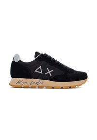 Scarpe atletiche nere con dettagli in camoscio e mesh, caratterizzate da una suola beige. Dettagli notevoli includono un logo grigio e la frase "Corri più veloce" sul lato.
