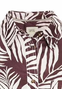 Korte mouwen shirt in donker maroen en wit met een bladerenpatroon. Voorzien van een button-down kraag en goudkleurige knopen. Etiket toont "Camel Active."