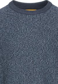 Pull marine texturé avec un col rond et un col côtelé. Le tissu présente un motif tissé avec des accents bleu clair.