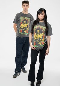 Gray cotton t-shirts featuring a colorful Bob Marley graphic. The design includes red, yellow, and green accents, with a relaxed fit.